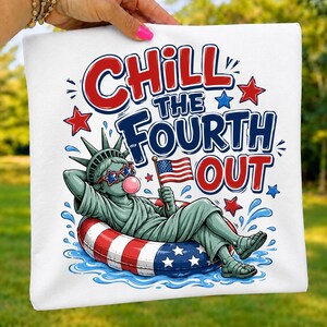 May include: A white t-shirt featuring a graphic of the Statue of Liberty wearing star-shaped sunglasses and blowing a pink bubble while lounging in a red, white, and blue inner tube, with the text CHILL THE FOURTH OUT and small stars.