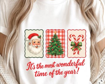 Op de afbeelding: Wit T-shirt met een kerstthema. Het ontwerp bevat afbeeldingen van de kerstman, een kerstboom en zuurstokken. De tekst "It's the most wonderful time of the year!" staat in rode letters onder de afbeeldingen. Het shirt heeft een klassieke ronde hals.