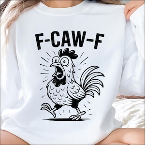 May include: White sweatshirt with a black and white cartoon rooster graphic. The rooster is depicted with wide eyes and an open beak, with the text "F-CAW-F" above it. The design is a humorous take on a rooster's crow.