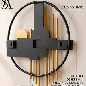 May include: A circular wall art piece featuring a black metal frame and a central black geometric structure. It includes vertical gold rods, a gold circular accent, and two keyhole mounts labeled EASY TO HANG, 3D FLOAT DESIGN, and New Pin points.