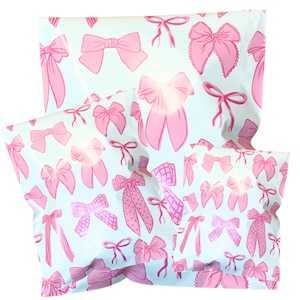 Könnte beinhalten: Mehrere hellblaue Versandtaschen mit einem sich wiederholenden Muster aus rosa Schleifen in verschiedenen Stilen. Die Schleifen sind in verschiedenen Größen und Designs gehalten und erzeugen eine verspielte und feminine Ästhetik. Die Taschen dienen wahrscheinlich zum Verpacken von Geschenken oder Waren.