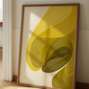 以下が含まれることがあります： 木製フレームに入った抽象的なアートプリント。このアートワークは、黄色とオリーブグリーンの色合いで流れるようなデザインが特徴です。プリントは壁に立てかけられており、モダンな美学を示しています。