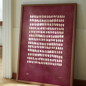 Op de afbeelding: Ingelijste kunstdruk met een bordeauxrode achtergrond en een patroon van witte, verticale penseelstreken. Het houten kunstwerk leunt tegen een muur. De print heeft het woord "grace" en "#225" erop.