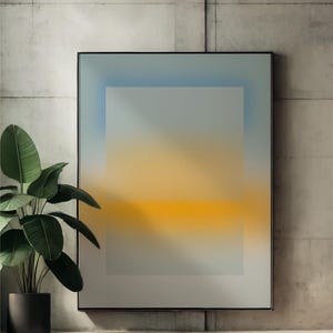 Puede incluir: Impresión artística abstracta en un marco negro. La obra presenta un degradado de colores, que transiciona del azul en la parte superior al amarillo en el centro, con un fondo gris. Una planta en maceta con hojas verdes grandes está en primer plano.