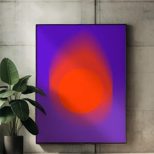 Puede incluir: Impresión artística abstracta con un círculo naranja vibrante sobre un fondo degradado púrpura, enmarcado en negro. La obra se exhibe contra una pared de hormigón, con una planta en maceta en primer plano.