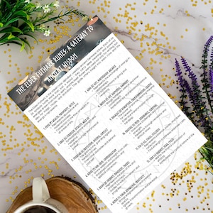 以下が含まれることがあります： 「エルダーフサルクのルーン：古代の知恵への入り口」というタイトルの印刷されたガイド。ルーンとその意味を説明するテキストが記載されています。ガイドは、花柄と星型の装飾が施された白い背景にあり、コーヒーカップがあります。