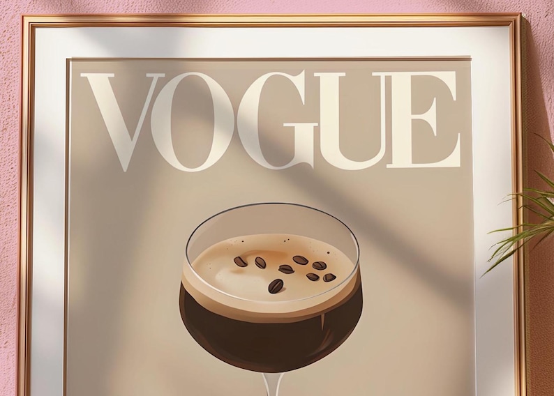 Puede incluir: Una impresi&oacute;n enmarcada de una portada de la revista Vogue que presenta un vaso de caf&eacute; con granos de caf&eacute; en la parte superior. El fondo es de color marr&oacute;n claro y el texto "Vogue" est&aacute; en blanco.