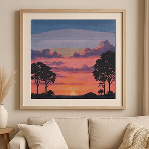 以下が含まれることがあります： 額縁に入った絵画。夕焼けと、前景にシルエットになった2本の木が描かれている。空はピンク、オレンジ、パープルの鮮やかな色合いで、ふわふわとした雲が広がっている。
