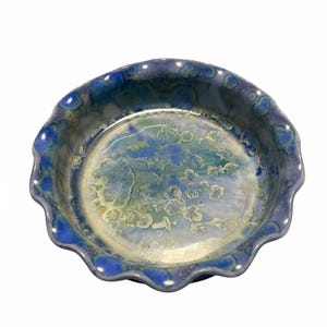 May include: A set of three ceramic mugs with a speckled, matte finish. The mugs are in shades of cream, light brown, and dark brown. Each mug has a simple, minimalist design, perfect for coffee or tea.