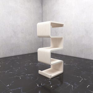 May include: A modern, cream-colored, zig-zag shaped shelf unit. The unit has four shelves and is made of vertical wooden slats. The unit is in a room with a black and white marble floor and gray walls.
