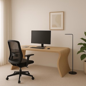 以下が含まれることがあります： 明るい木製の机、黒いコンピューターモニター、キーボード、マウスを備えたモダンなホームオフィス。黒いメッシュのオフィスチェアが机の前にあります。額入りのアートワークと鉢植えの植物が、ミニマリストデザインを完成させています。