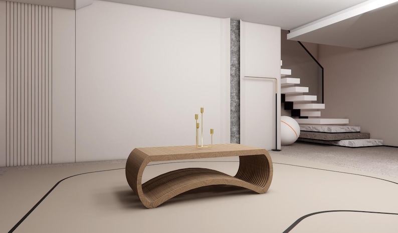 May include: A modern, curved wooden coffee table with a layered design. The table is light brown and has a unique, open-bottom design. Gold candle holders with three candles are on top. The room has a neutral color palette.