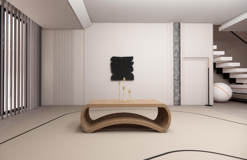 May include: A modern living room with a light wood coffee table and gold candle holders. A black abstract art piece hangs on the wall. The room has a neutral color palette with a curved design on the floor.