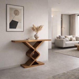 May include: A wooden console table with an unusual, interwoven base. The table is made of light-coloured wood and has a vase of dried flowers and books on top. An abstract framed artwork hangs on the wall above the table. The room has a modern design.