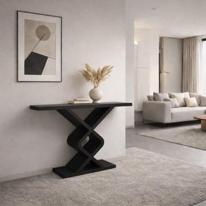 May include: A black console table featuring a flat rectangular top and a base constructed with two interlocking geometric shapes that form a central X-like structure. The table stands on a solid rectangular base plate, providing a stable foundation.