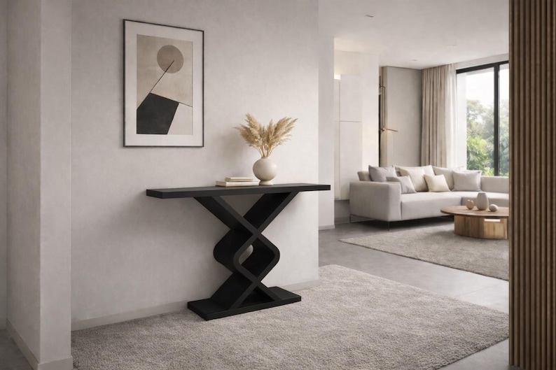 May include: A black console table featuring a flat rectangular top and a base constructed with two interlocking geometric shapes that form a central X-like structure. The table stands on a solid rectangular base plate, providing a stable foundation.