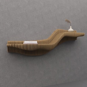 Puede incluir: Estantería de madera moderna y ondulada, fijada a una pared gris. Exhibe un pequeño jarrón blanco con flores secas y un libro. El diseño utiliza listones en capas, formando una forma orgánica. La estantería mide aproximadamente 120 cm de largo.