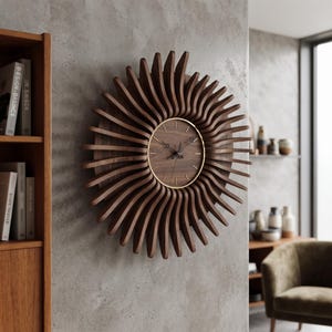 May include: A circular wall clock featuring a dark brown wooden frame with curved, radiating slats that resemble sun rays. The clock face is made of matching dark wood with thin gold-colored hour markers and black hands, enclosed by a thin gold rim.