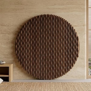 May include: A large, round, wooden wall art piece with a textured, vertical groove design. The art is brown and mounted on a beige wall. A bonsai tree is visible through a window, adding a natural element to the room.