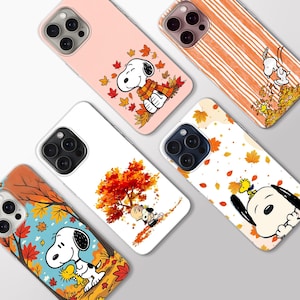 Puede incluir: Cinco fundas para smartphone con Snoopy y Woodstock en diversas escenas otoñales. Los diseños incluyen a Snoopy sentado entre hojas coloridas, caminando sobre rayas naranjas, bajo un árbol rojo vibrante y primeros planos junto a Woodstock.