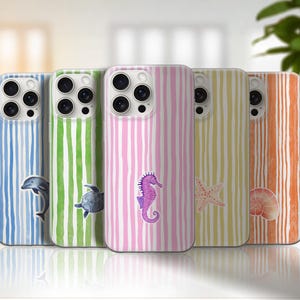 May include: Five smartphone cases arranged in a row, each featuring vertical watercolor stripes in blue, green, pink, yellow, and orange. Each case displays a single marine life illustration: a dolphin, a sea turtle, a seahorse, a starfish, and a shell.