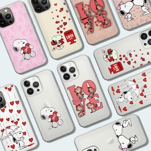 Op de afbeelding: Een collectie van doorzichtige en gekleurde smartphonehoesjes met Snoopy-figuren in diverse romantische scènes met rode harten, liefdesbrieven, brievenbussen en paraplu's, waarbij sommige hoesjes het woord LOVE in grote letters tonen.