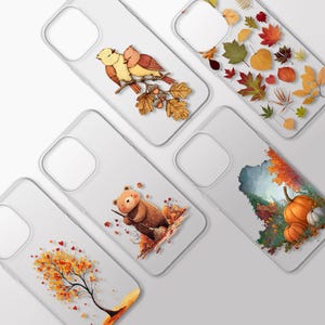 Può includere: Cinque cover trasparenti per telefono con disegni a tema autunnale. Una mostra due uccellini su un ramo di quercia, un'altra foglie autunnali sparse, una un orso che spazza le foglie, una un campo di zucche e l'ultima un albero con foglie arancioni.
