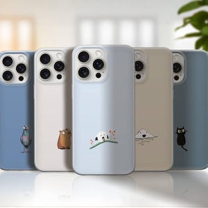 Könnte beinhalten: Fünf Smartphone-Hüllen in einer Reihe, jede mit einer einzigartigen minimalistischen Tierillustration. Die Hüllen sind in den Farben Blau, Weiß, Hellgrau, Beige und Dunkelblau gehalten und zeigen einen Vogel, einen Bären, einen Hund, eine Robbe und eine Katze.