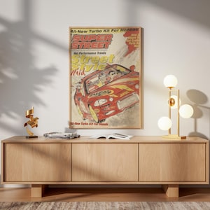 May include: A wooden cabinet with three doors, a gold lamp with spherical bulbs, and a framed poster of a red sports car. The poster reads "Super Street" and "Street Style Wild."