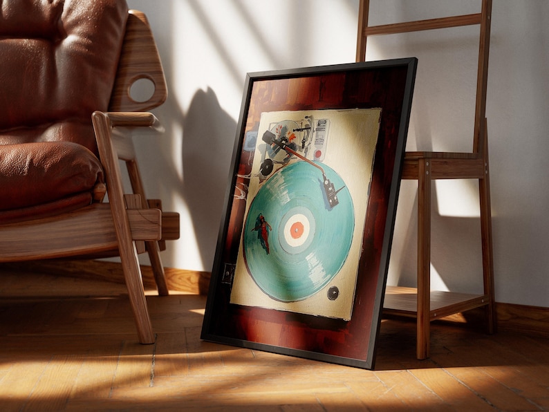 May include: A framed artwork featuring a vintage-style illustration of a record player with a teal record. The artwork is in a dark wooden frame, leaning against a wall. The scene includes a wooden chair and a wooden shelf.