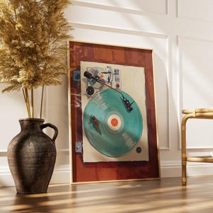 May include: A framed art print of a vintage record player with a teal record. The artwork has a warm color palette with a red-brown border and a light beige background. A dark brown vase with dried plants is to the left.