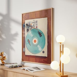 May include: A framed artwork depicts a vintage record player with a teal record. The artwork is mounted on a white wall above a wooden cabinet. A modern lamp with four spherical lights and a gold sculpture are on the cabinet.