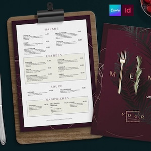 May include: A wooden clipboard holding a white menu with black text under headings like Salade, Entrées, Soupe, and Sandwiches, alongside a dark burgundy menu cover featuring a gold fork illustration, a sprig of rosemary, and the text Menu Your Restaurant.