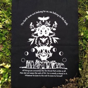 May include: Black fabric with white text and a graphic design. The text reads "The Earth does not belong to us, we belong to the Earth."  "All things are connected like the blood that unites us all. Man did not weave the web of life. He is merely a strand in it. Whatever he does to the web he does to himself."