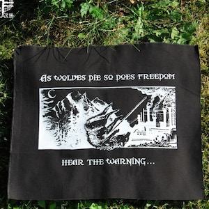 Könnte beinhalten: Schwarz-weißes Patch mit dem Text "As wolves die so does freedom" und "Hear the warning..."  Das Patch zeigt eine Grafik eines Wolfes, der vor einer Fabrik mit Schornsteinen davonläuft.