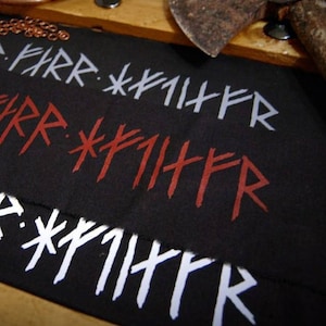 May include: Black fabric patch with three rows of white and red runes, reading "LIR FARR *#1HFR", "*A PARR *FIIHFR", and "XIR FARR *PIHER".