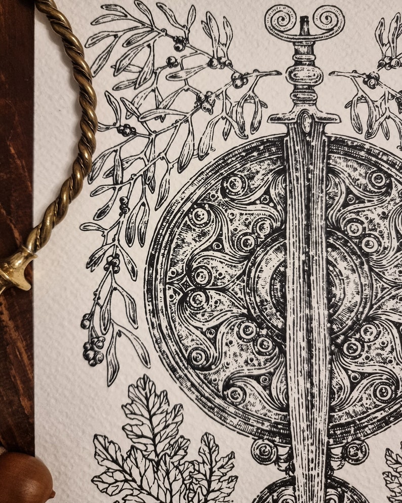 May include: A black and white illustration of a sword and shield with intricate designs. The sword is surrounded by a wreath of mistletoe and oak leaves.