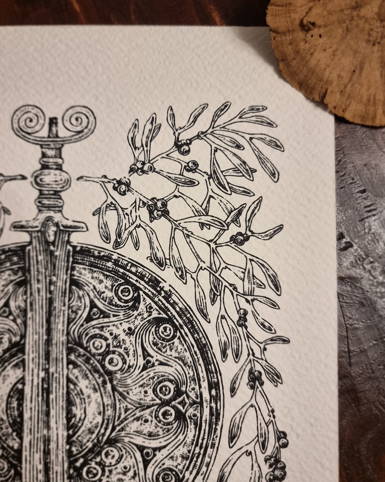 May include: A black and white illustration of a sword and shield with a sprig of mistletoe with berries.