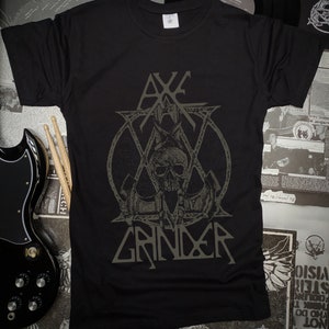 May include: Black t-shirt with a gray graphic of a skull with a crown and the text "Axe Grinder".