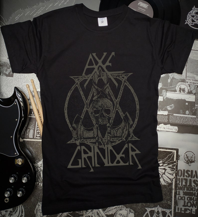 May include: Black t-shirt with a gray graphic of a skull with a crown and the text "Axe Grinder".