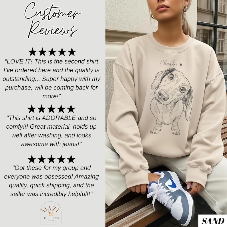 May include: Sand-colored sweatshirt featuring a sketched dachshund dog illustration with the name "Charlie" above it. The sweatshirt is part of a collection, as indicated by the "MAZE DESIGNS" logo. Customer reviews are also visible.
