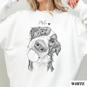 May include: White sweatshirt featuring a black and white dog illustration with its tongue out. The name "Milo" is written above the dog's head, with a heart symbol. The word "WHITE" is printed in the bottom right corner.