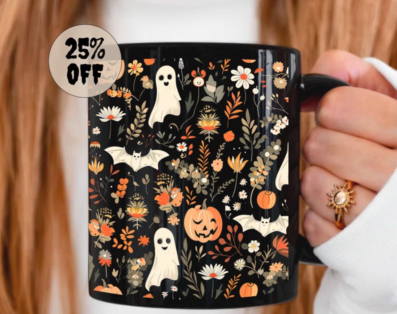 May include: Black ceramic mug with a Halloween-themed floral design. The design includes white ghosts, bats, pumpkins, and various flowers in orange, white, and yellow. The mug has a black handle and the text "25% OFF" in a circular sticker.