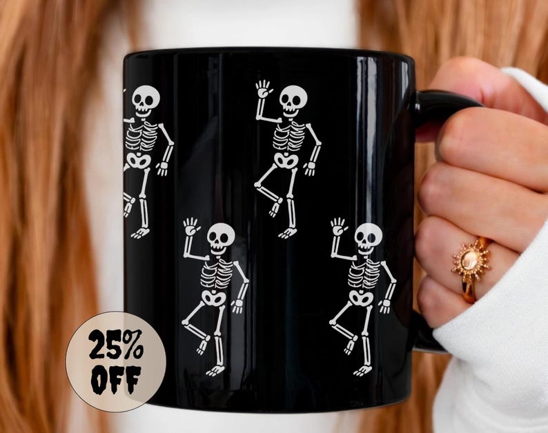 May include: A black ceramic mug featuring a repeating pattern of white skeleton illustrations. The skeletons are depicted in a waving pose. A circular sticker on the mug reads "25% OFF".