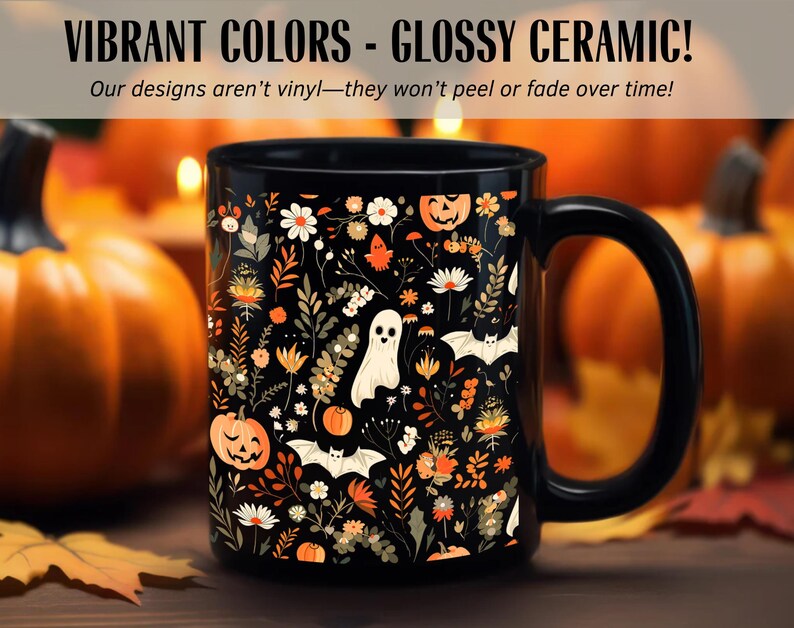 May include: Black ceramic mug with a Halloween-themed floral design. The mug features pumpkins, ghosts, and bats among flowers in orange, white, and beige. Text on the mug reads "VIBRANT COLORS - GLOSSY CERAMIC!" and "Our designs aren't vinyl-they won't peel or fade over time!"