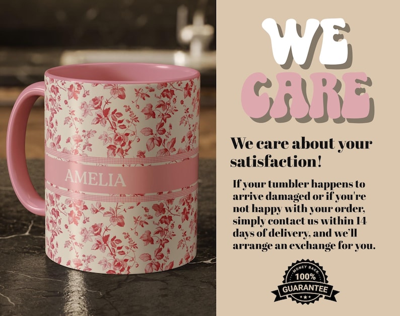 May include: A ceramic mug with a pink interior and handle, featuring a floral pattern in red and white. A pink band with the name "AMELIA" is wrapped around the mug. The mug is on a dark surface.