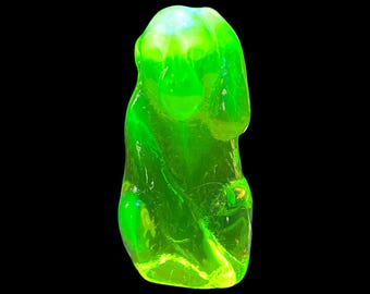 May include: A bright green glass figurine of a sitting monkey. The figurine is made of uranium glass and glows under a black light.