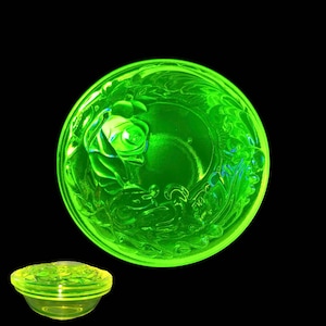 Peut inclure: Un bol en verre vert avec un motif floral. Le bol est en verre d'uranium et brille sous une lumière noire.