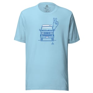 Könnte beinhalten: Hellblaues T-Shirt mit einer blauen Umrisszeichnung eines Vintage-Vans mit einer Peace-Handgeste. Der Van hat das Wort "GREEDY" oben und "1979" auf dem Nummernschild.