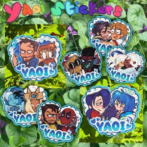 May include: A collection of seven die-cut stickers featuring various illustrated character pairs in a cartoon style. Each sticker has a scalloped white border, blue heart accents, and the word YAOI printed in a bold, blue, stylized font at the bottom.